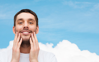 Image showing beautiful smiling man touching his face