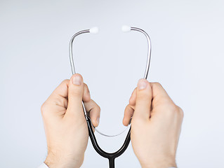 Image showing doctor hand with stethoscope listening something