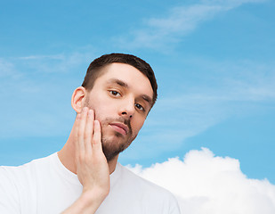 Image showing beautiful calm man touching his face