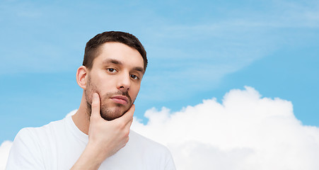 Image showing beautiful calm man touching his face