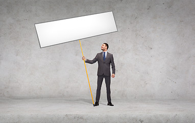 Image showing smiling businessman holding white blank board