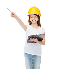 Image showing little girl in protective helmet with clipboard