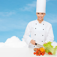 Image showing smiling female chef chopping vegetables