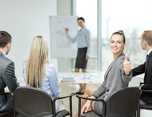 Image showing businesswoman with team showing thumbs up