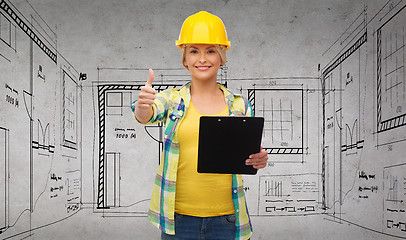 Image showing smiling woman in helmet with clipboard