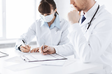 Image showing doctor and nurse writing prescription paper