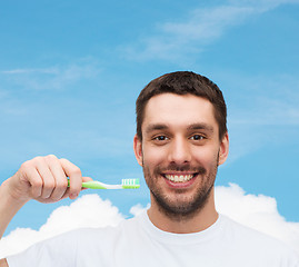 Image showing smiling young man with toothbrush