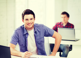 Image showing smiling student with laptop at school