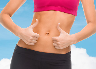 Image showing close up of female abs and hands showing thumbs up