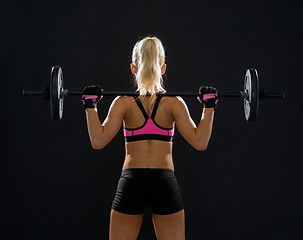 Image showing sporty woman exercising with barbell from back