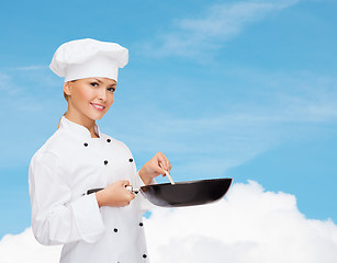 Image showing smiling female chef with pan and spoon