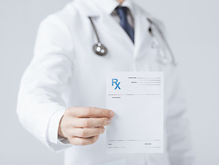 Image showing male doctor holding rx paper in hand