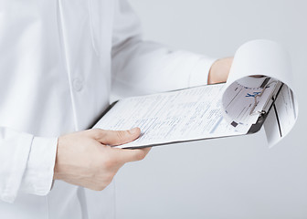 Image showing male doctor holding prescription paper in hand