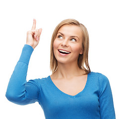 Image showing smiling woman pointing her finger up