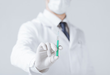 Image showing male doctor holding syringe with injection