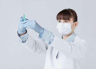 Image showing female doctor holding syringe with injection