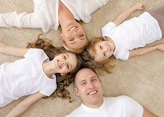 Image showing parents and two girls lying on floor at home