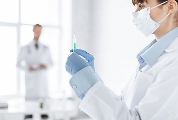 Image showing female doctor holding syringe with injection