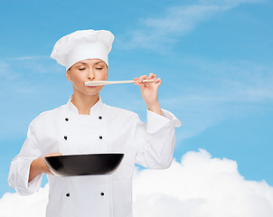 Image showing smiling female chef with pan and spoon