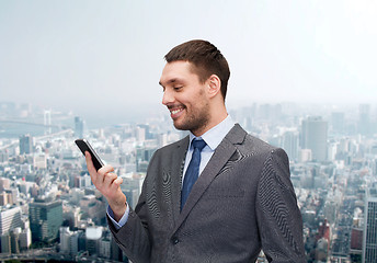 Image showing young smiling businessman with smartphone