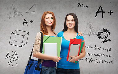 Image showing two smiling students with bag, folders and tablet