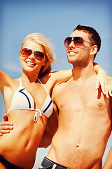 Image showing happy couple in sunglasses on the beach