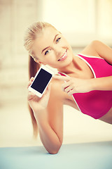 Image showing woman lying on the floor with smartphone