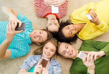 Image showing group of smiling people lying down on floor