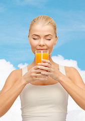 Image showing young woman drinking orange juice