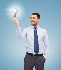 Image showing handsome businessman holding light bulb