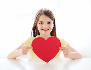 Image showing smiling little girl with red heart at home