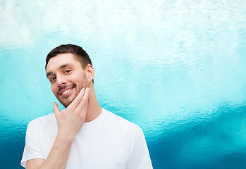 Image showing beautiful smiling man touching his face