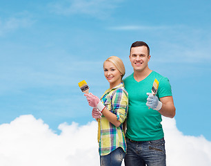 Image showing smiling couple with paintbrush