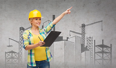 Image showing smiling woman in helmet with clipboard