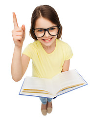 Image showing smiling little girl in eyeglasses with book