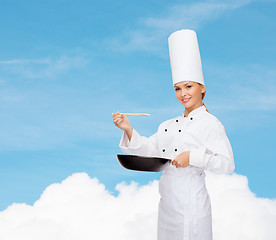 Image showing smiling female chef with pan and spoon