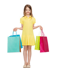 Image showing smiling little girl in dress with shopping bags