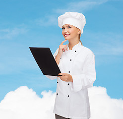 Image showing smiling female chef with black blank paper