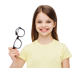 Image showing smiling cute little girl holding black eyeglasses