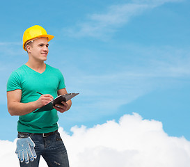 Image showing smiling man in helmet with clipboard