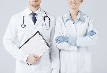 Image showing nurse and male doctor holding cardiogram