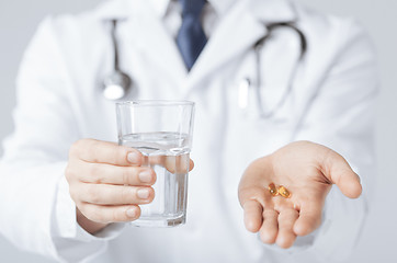 Image showing doctor hands giving capsule and glass of water