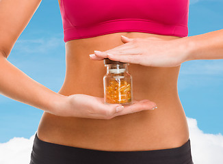 Image showing close up of female hands with bottle of capsules