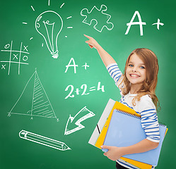 Image showing cute girl with folders pointing to green board