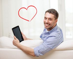 Image showing smiling man working with tablet pc at home