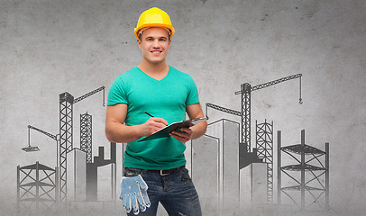 Image showing smiling man in helmet with clipboard