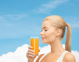 Image showing young woman drinking orange juice