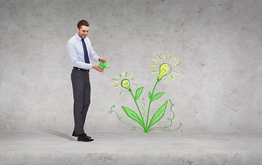 Image showing handsome businessman with green watering can