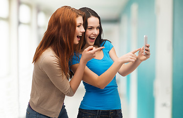 Image showing two smiling teenagers with smartphone