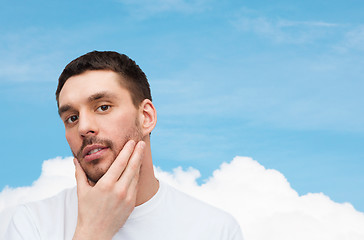 Image showing beautiful calm man touching his face